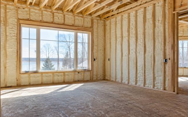 Stud walls filled with spray foam in a new home before drywall in Elmira